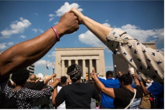 Black hand holding white hand